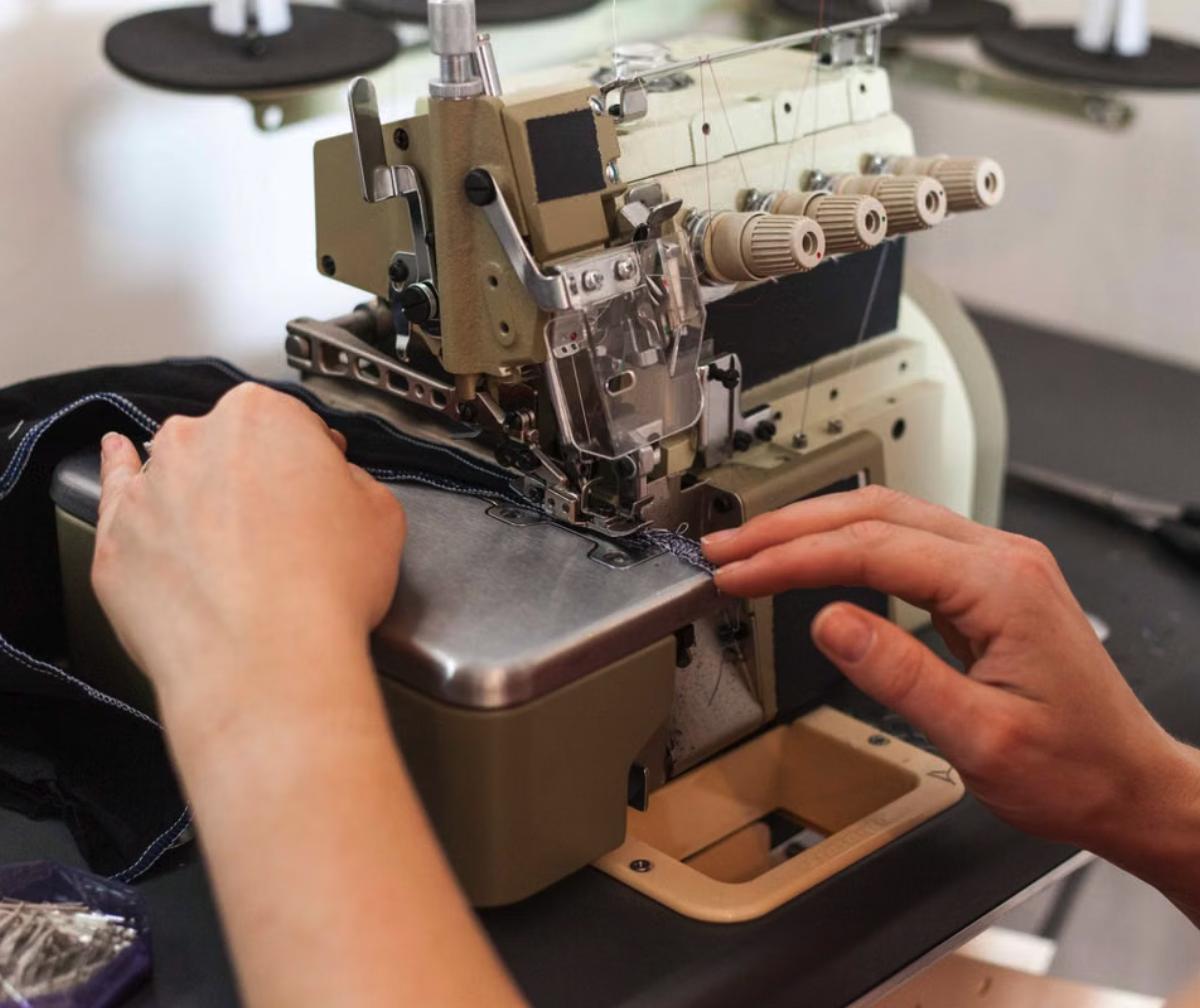 Remalladora industrial overlock cosiendo tela en taller de confección