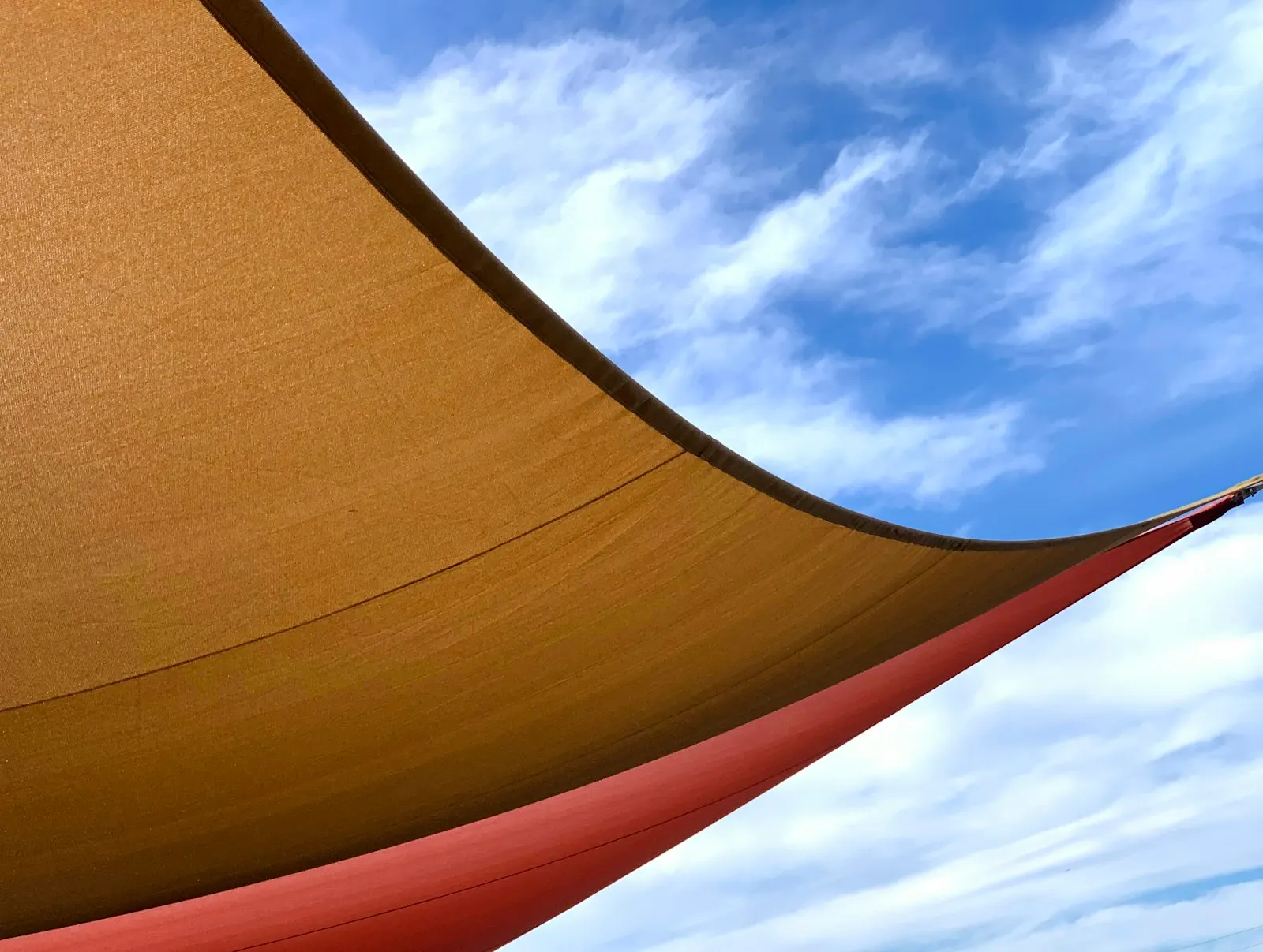 Toldo vela de lona tensado bajo el cielo